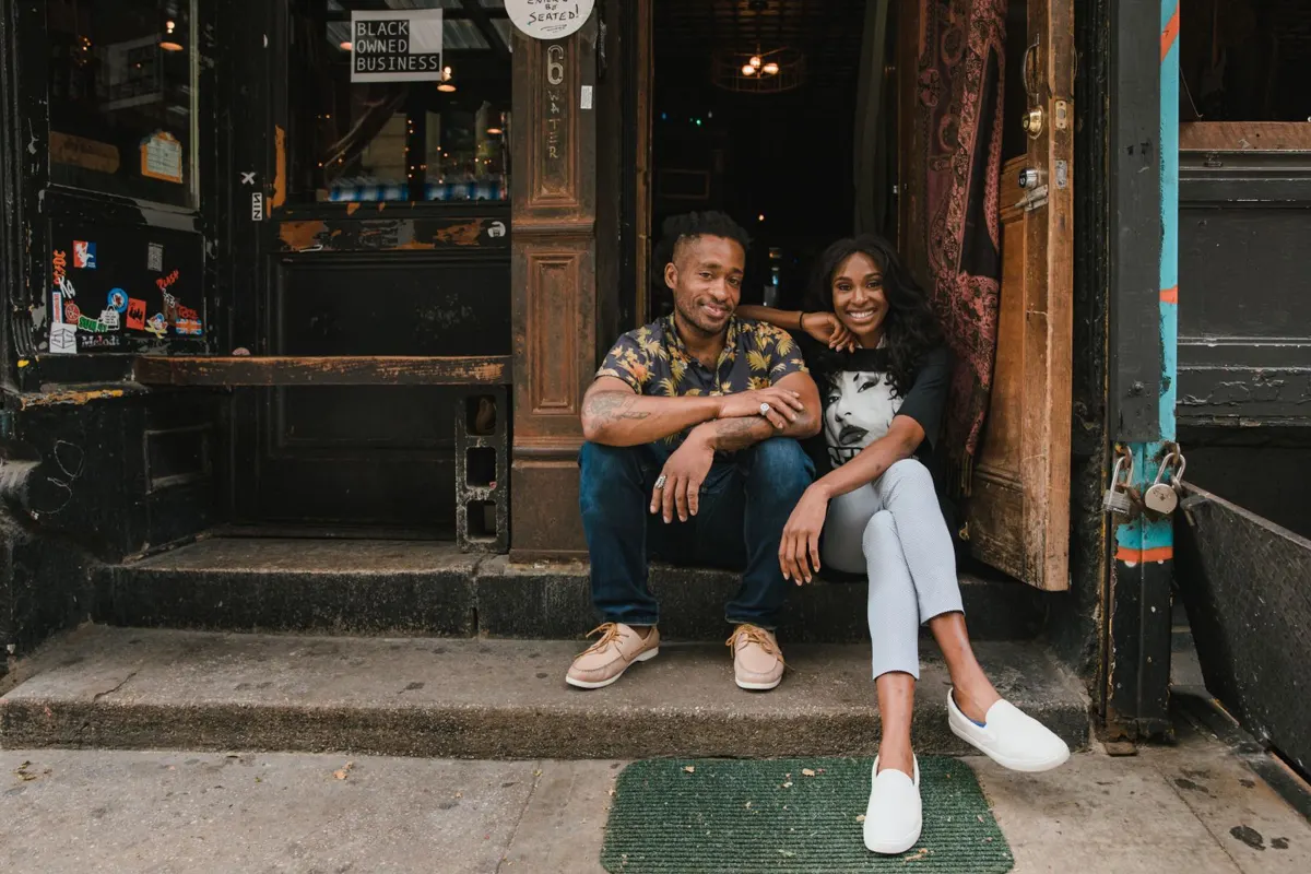 Small business owners smiling in front of their cafe