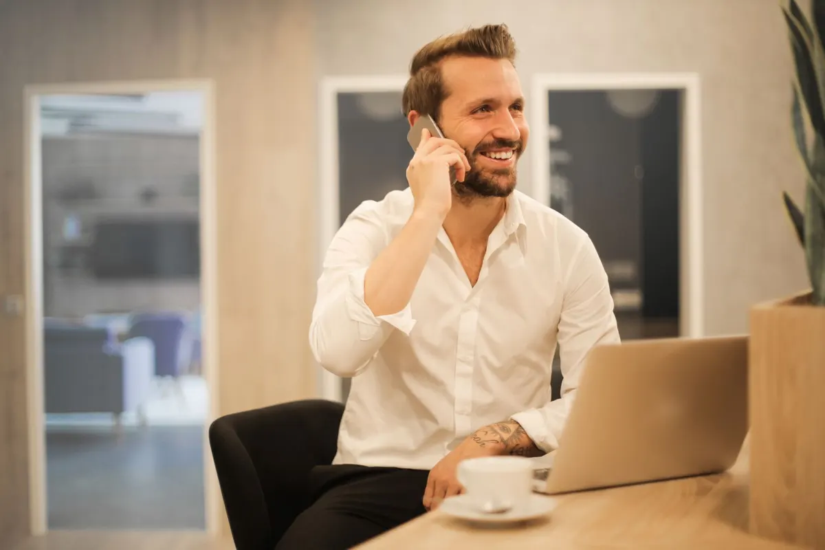 Smiling agent on a phone call at his desk