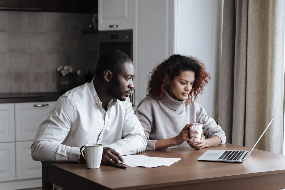Couple reviewing options together on a laptop at home